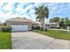 Tan house with white garage door and neatly landscaped yard at 1364 Berkshire Ct, Venice, FL 34292