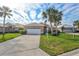 Tan house with white garage door and lush landscaping, inviting curb appeal at 1364 Berkshire Ct, Venice, FL 34292