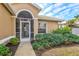 Front entry with a screened porch and well-maintained landscaping at 1364 Berkshire Ct, Venice, FL 34292