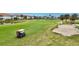 Golf course view with a golf cart and players at 1364 Berkshire Ct, Venice, FL 34292