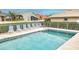 Community pool with striped lounge chairs at 1364 Berkshire Ct, Venice, FL 34292