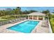 Community pool with lounge chairs and a covered patio at 1364 Berkshire Ct, Venice, FL 34292