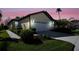 House exterior view at dusk showcasing a two-car garage and landscaping at 1410 Maseno Dr, Venice, FL 34292