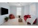 Living room featuring a red couch, armchair, and a neutral rug at 1410 Maseno Dr, Venice, FL 34292