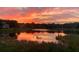 Beautiful sunset reflected in a serene lake setting at 146 Willow Bend Way, Osprey, FL 34229