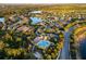 Aerial view of a community featuring beautiful homes, a sparkling lake, lush greenery, and a resort-style pool at 15326 Castle Park Ter, Lakewood Ranch, FL 34202