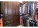 Walk-in closet featuring dark wood built-in shelving and drawers, providing ample storage space for clothing and accessories at 15326 Castle Park Ter, Lakewood Ranch, FL 34202