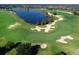 Scenic aerial view of a golf course with sand traps and a tranquil lake at 15326 Castle Park Ter, Lakewood Ranch, FL 34202