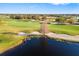 Scenic golf course view showcasing lush green fairways, a pristine pond, and mature trees under a clear blue sky at 15326 Castle Park Ter, Lakewood Ranch, FL 34202