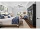 Serene main bedroom with tray ceilings, plantation shutters, a bench, and dark wood armoire at 15326 Castle Park Ter, Lakewood Ranch, FL 34202