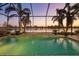 Sparkling pool set against a backdrop of swaying palms and tranquil sunset views over the lake at 15326 Castle Park Ter, Lakewood Ranch, FL 34202