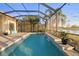 Enclosed pool area featuring a waterfall feature and views of the well-maintained lawn and surrounding area at 15326 Castle Park Ter, Lakewood Ranch, FL 34202