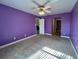 Large bedroom with purple walls, carpet, and ceiling fan at 1535 Nursery Rd # 107, Clearwater, FL 33756