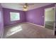 Bedroom with purple walls, carpet, and a window for natural light at 1535 Nursery Rd # 107, Clearwater, FL 33756