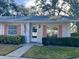 Front view of a single story home with manicured lawn and pink shutters at 1535 Nursery Rd # 107, Clearwater, FL 33756