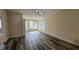 Bright living room with wood-look floors and access to other rooms at 1535 Nursery Rd # 107, Clearwater, FL 33756