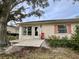 Private patio area with red chair and lush landscaping at 1535 Nursery Rd # 107, Clearwater, FL 33756