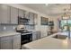 Modern kitchen with stainless steel appliances and gray cabinets at 17209 Barnwood Pl, Bradenton, FL 34211