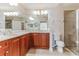 Tiled bathroom with double sinks, marble countertops, and a glass shower at 17278 Acapulco Rd # 312, Punta Gorda, FL 33955