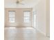 Bright living room featuring tile flooring and two windows with blinds, and door to the balcony at 17278 Acapulco Rd # 312, Punta Gorda, FL 33955