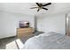 Spacious bedroom featuring a ceiling fan, gray carpet, and a dresser with a television at 17395 Palmetto Pass Ln, Punta Gorda, FL 33982