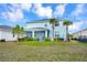 Back exterior view featuring palm trees, a screened lanai, and a grassy yard at 17395 Palmetto Pass Ln, Punta Gorda, FL 33982