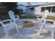 Relaxing fire pit area with four white chairs at 1752 Banyan Dr, Venice, FL 34293