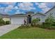 One-story home with gray siding, white garage door, and manicured lawn at 17723 Gulf Ranch Pl, Lakewood Ranch, FL 34211