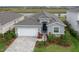 Gray house with white garage door, landscaping, and a paved driveway at 17723 Gulf Ranch Pl, Lakewood Ranch, FL 34211