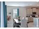 Modern kitchen with gray cabinets and an island, a dining area with a wooden table at 17723 Gulf Ranch Pl, Lakewood Ranch, FL 34211