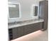 Modern bathroom with double vanity, illuminated mirrors, and gray cabinets at 2110 Michele Dr, Sarasota, FL 34231