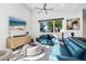 Modern living room with teal couches, large windows and a coffee table at 2254 Hawthorne St, Sarasota, FL 34239