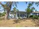 A view of the backyard with mature trees, a screened in porch and a small yard at 2321 Terry Ln, Sarasota, FL 34231