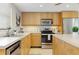 Well-lit kitchen with stainless steel appliances, light wood cabinets, and ample counter space at 2321 Terry Ln, Sarasota, FL 34231