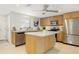 Bright kitchen with stainless steel appliances, wooden cabinets, and a central island for meal preparation at 2321 Terry Ln, Sarasota, FL 34231