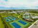 Aerial view of community amenities including tennis courts, pool, playground, and expansive green areas at 2582 Wild Cherry Path, Sarasota, FL 34240