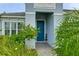 Inviting front entrance with blue door and lush landscaping at 2582 Wild Cherry Path, Sarasota, FL 34240