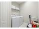 Convenient laundry room with washer, dryer, and storage shelves at 2582 Wild Cherry Path, Sarasota, FL 34240