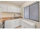 Functional kitchen featuring white cabinets, neutral countertops, and a bright window at 3101 Bee Ridge Rd # 118, Sarasota, FL 34239