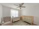 Bright bedroom with hardwood floors, a crib, a cozy chair, and natural light at 3302 21St Avenue W Dr, Bradenton, FL 34205