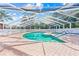 Outdoor screened pool area with brick pavers surrounding the pool and hot tub at 3622 Bonaventure Ct, Sarasota, FL 34243