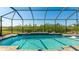 Inviting, refreshing pool with a screened enclosure and lush greenery backdrop at 413 Wildlife Gln, Bradenton, FL 34209