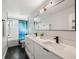 Modern bathroom with double vanity, white cabinets, and geometric floor tiles at 416 Giovanni Dr, Nokomis, FL 34275