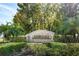 Community entrance sign with lush landscaping and palm trees at 4901 Fallcrest Cir, Sarasota, FL 34233