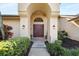 Inviting entryway with arched doorway and lush landscaping at 4901 Fallcrest Cir, Sarasota, FL 34233