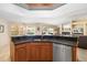 Kitchen island with sink, granite countertop, and stainless steel dishwasher at 4901 Fallcrest Cir, Sarasota, FL 34233