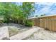 Side yard view showing a pathway, wooden fence, and tropical plants at 500 N Jefferson Ave # C3, Sarasota, FL 34237