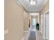 Bright hallway with tile flooring, elegant rug, and decorative lighting leading to the home's entrance at 5001 65Th E Ter, Ellenton, FL 34222