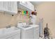 Functional laundry room equipped with modern washer and dryer units and storage shelves at 5001 65Th E Ter, Ellenton, FL 34222