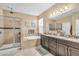 Luxurious bathroom featuring a soaking tub, glass-enclosed shower, double vanity, and stylish fixtures at 5001 65Th E Ter, Ellenton, FL 34222